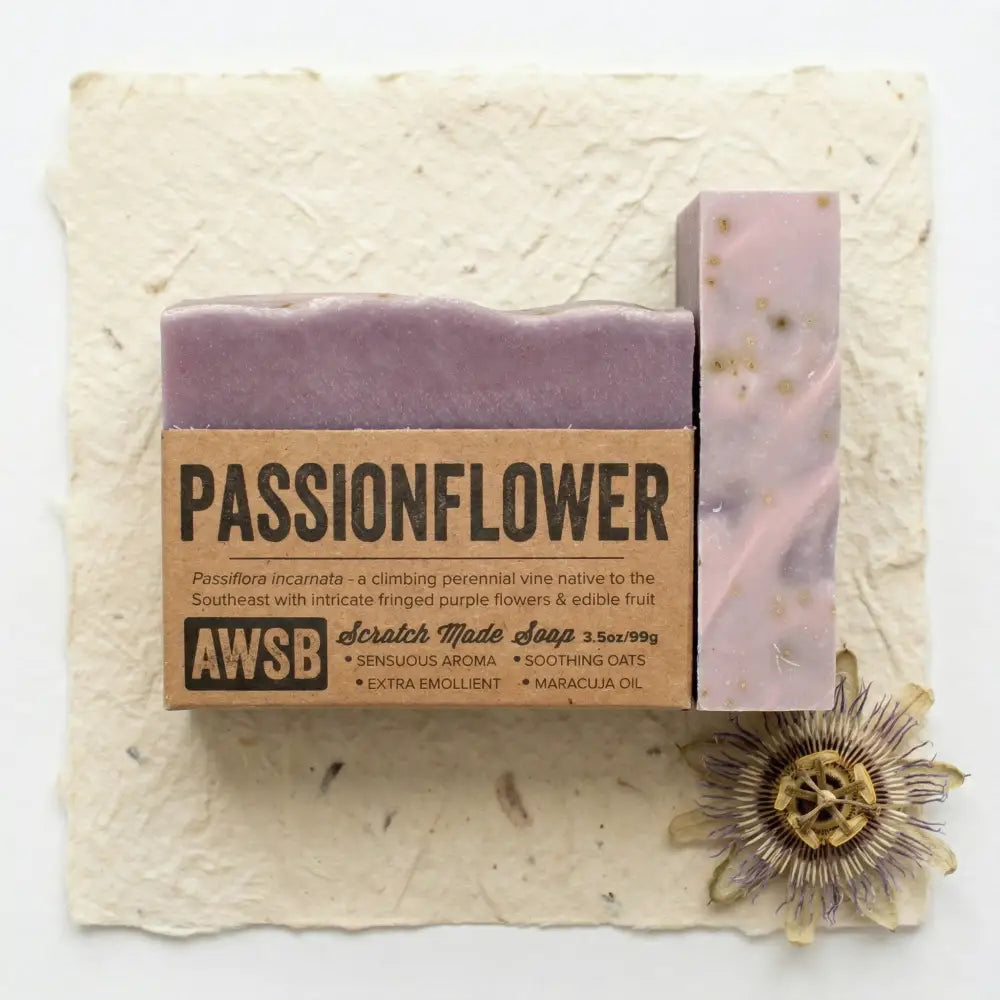 Purple passionflower bar soap with speckled texture and natural brown paper packaging infused with passion fruit seed and ylang ylang