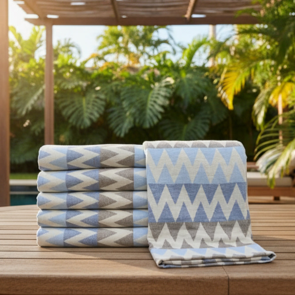 Stacked rolls of light blue and gray zigzag patterned organic turkish cotton towels 36x78 for beach use