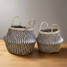 Two handmade belly baskets with black zig-zag patterns and natural handles