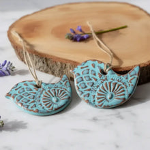 Turquoise ceramic bird ornament with brown embossed patterns and natural twine hanger perfect for bird lovers