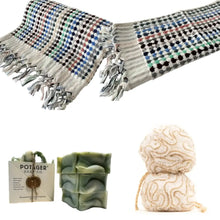 Colorful patterned cotton bath towel with fringe, green soap, and bath poufs for authentic Turkish bath experience