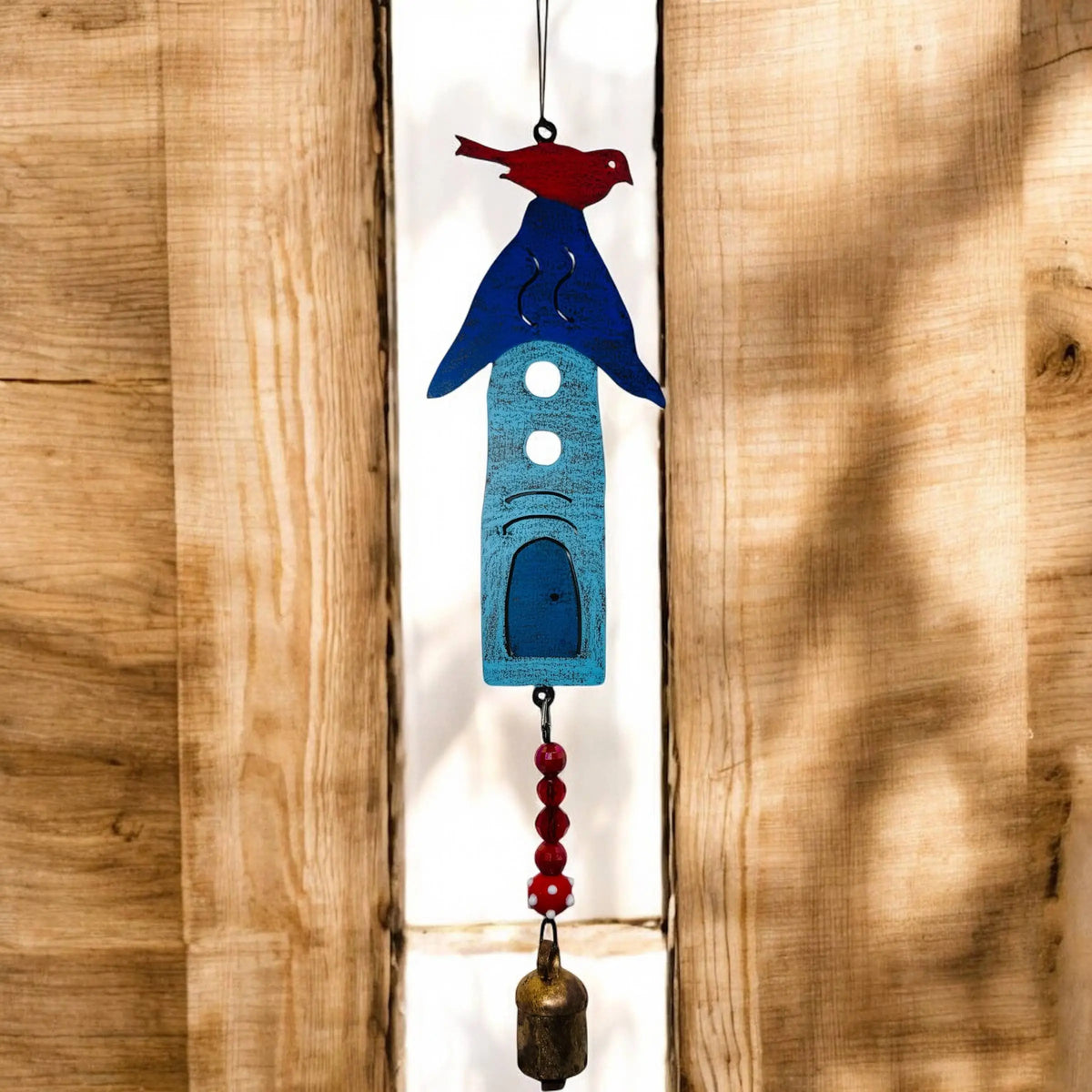 A whimsical handmade blue and red metal birdhouse wind chime with eco-friendly beads and hanging bell for outdoor decor