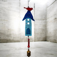 A handmade eco-friendly blue metal birdhouse wind chime with red bird, white cutouts, beads and bronze bell