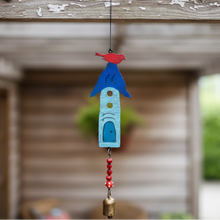 A handmade eco-friendly blue metal birdhouse wind chime with red bird, white cutouts, beads and bronze bell
