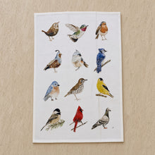 White cotton flour sack tea towel with watercolor illustrations of twelve different birds in naturalistic poses