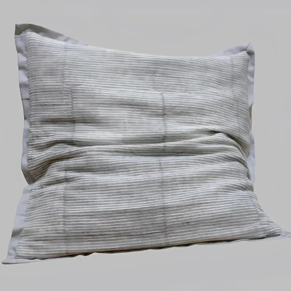 Pillow cover features a rusty-peach colored cotton gauze material with a hand block print design in a neutral color and has a zipper closure on the back side.
