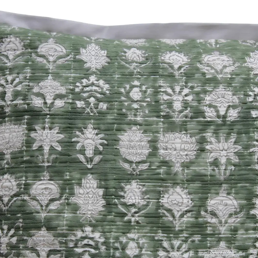 Pillow cover features a green colored cotton gauze material with a hand block print design in a neutral color and has a zipper closure on the back side.
