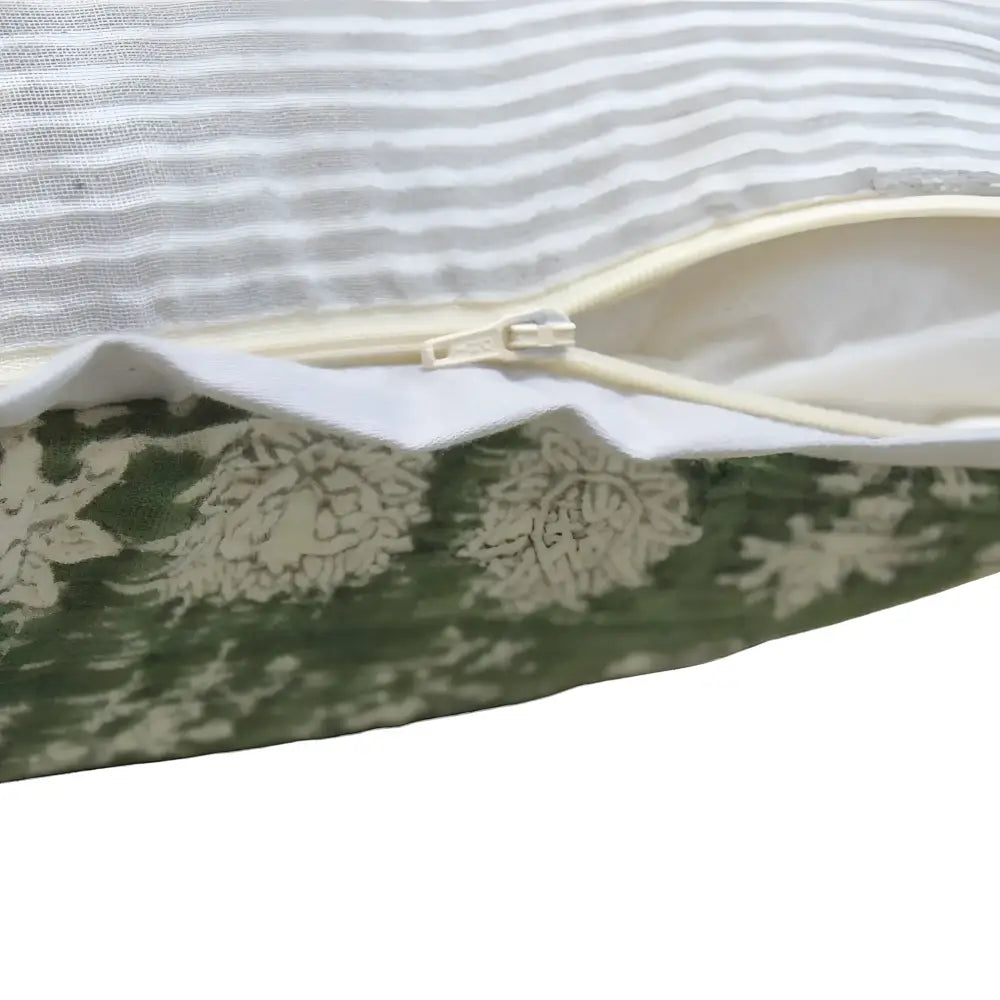 Pillow cover features a green colored cotton gauze material with a hand block print design in a neutral color and has a zipper closure on the back side.