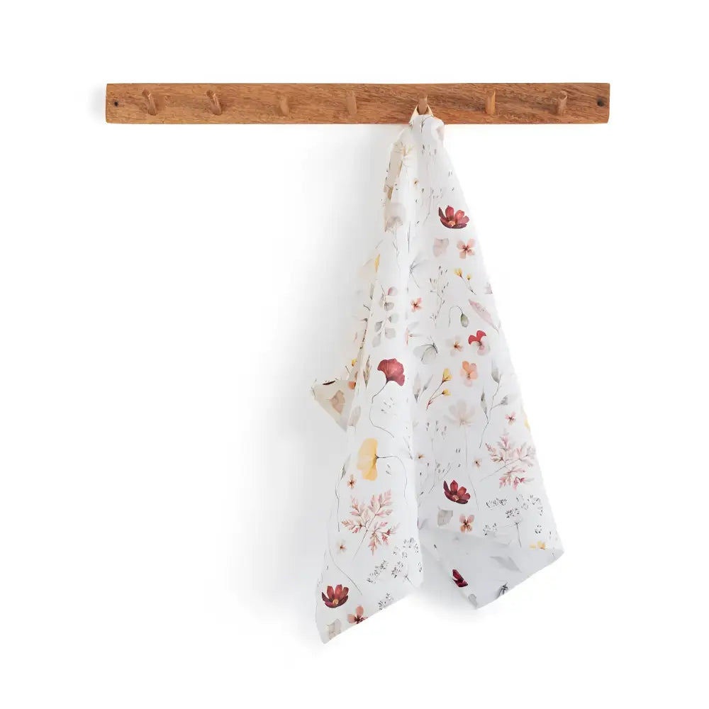 Blossom Nest tea towel with floral pattern on wooden rack