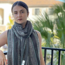 Woman wearing a dark gray striped scarf from Bold Stripes Turkish Towel collection