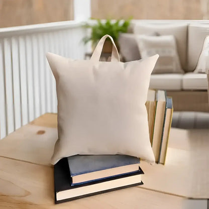 Handmade beige canvas Bookworm Nest pillow with handle on books