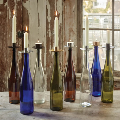 A colorful collection of eco-friendly handmade glass wine bottle candle holders with metallic rims called bottelabra taper gold