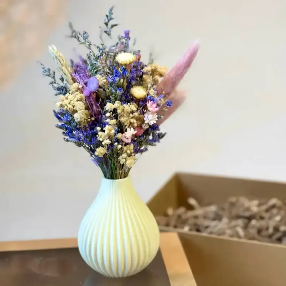 A pale green ribbed ceramic vase with a colorful dried floral bouquet perfect for boyds custom fabrication gifts
