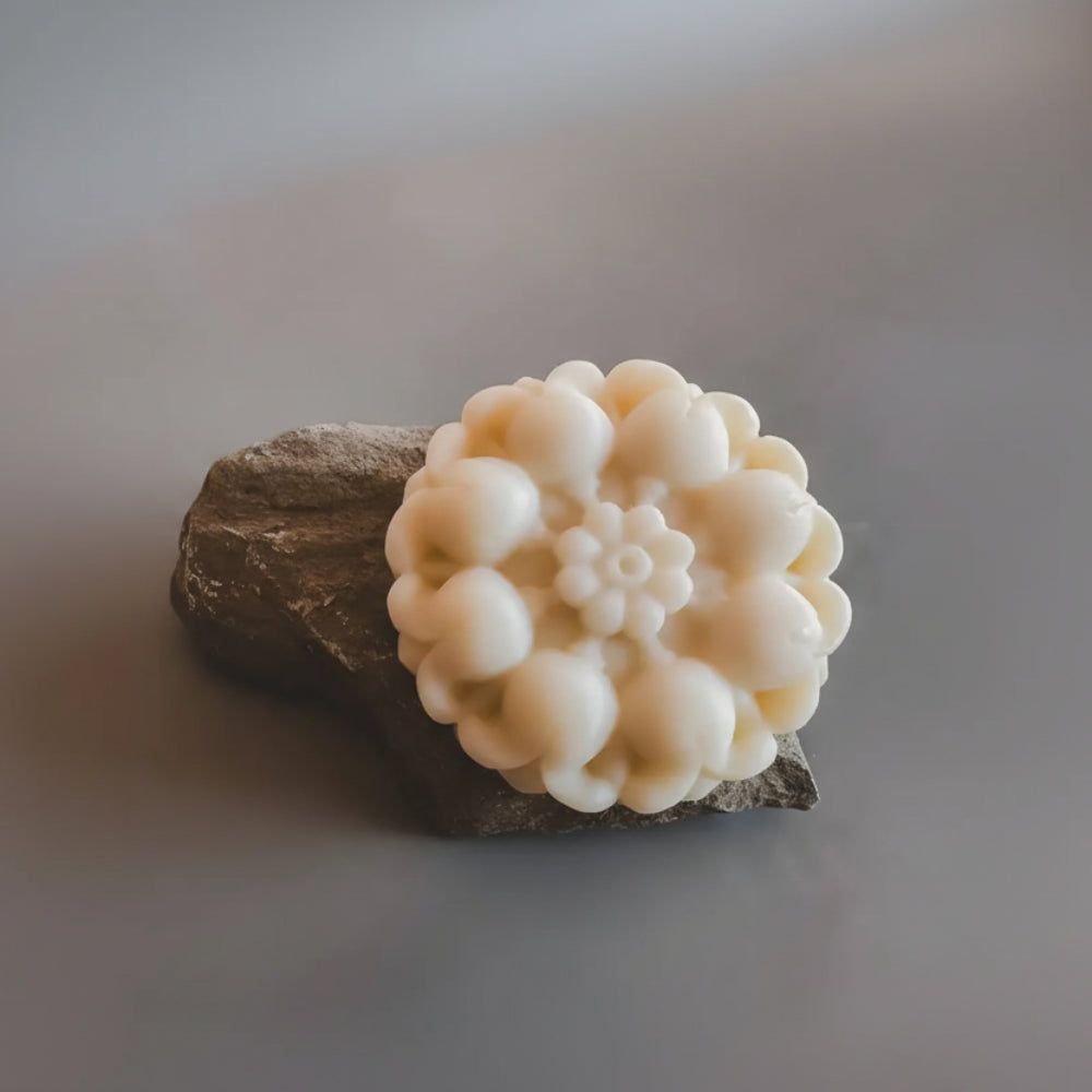 Cream-colored floral handmade soap Flora N° 11 on dark stone