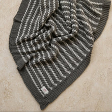 A cozy organic cotton throw with natural zigzag knit and soft gray off-white stripes perfect for chunky-knit beauty lovers