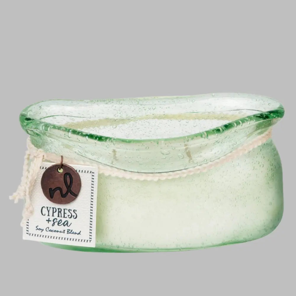 A hand-blown glass vessel with an artisan-rolled rim filled with natural candle wax with two wicks. 
