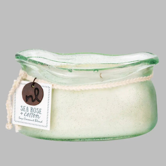 A hand-blown glass vessel with an artisan-rolled rim filled with natural candle wax with two wicks. 