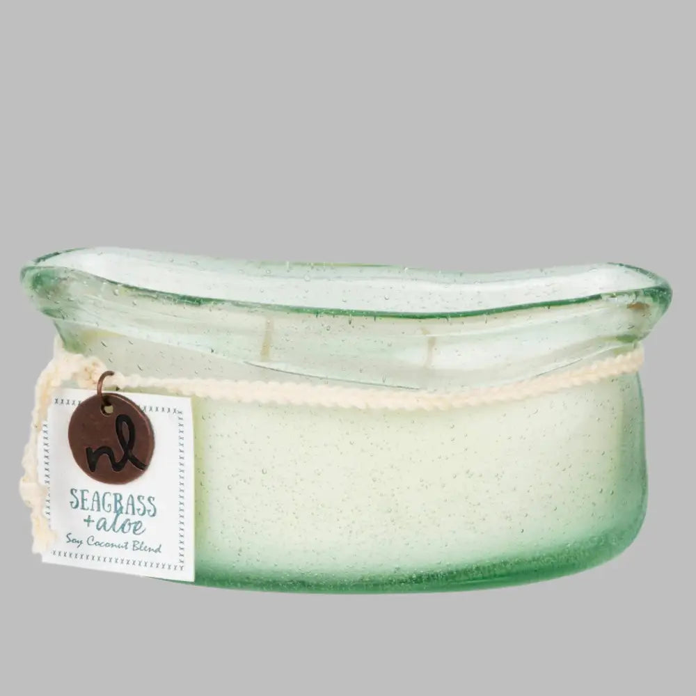 A hand-blown glass vessel with an artisan-rolled rim filled with natural candle wax with two wicks. 
