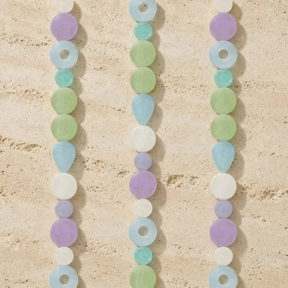 Pastel-colored capiz strand watch light dance with iridescent shells in lavender, mint green, light blue, and white beads