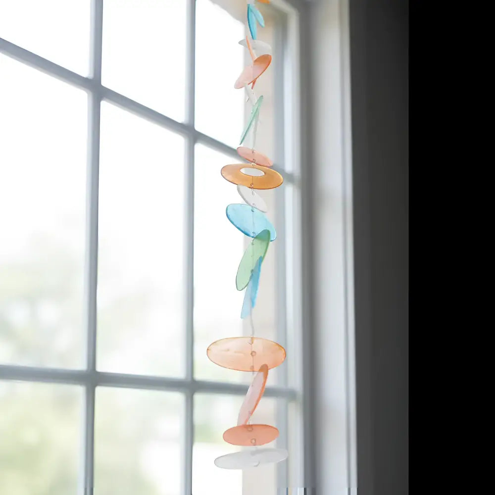 Colorful translucent capiz strand wind chime in orange blue and green watch light dance with circular and oval pieces
