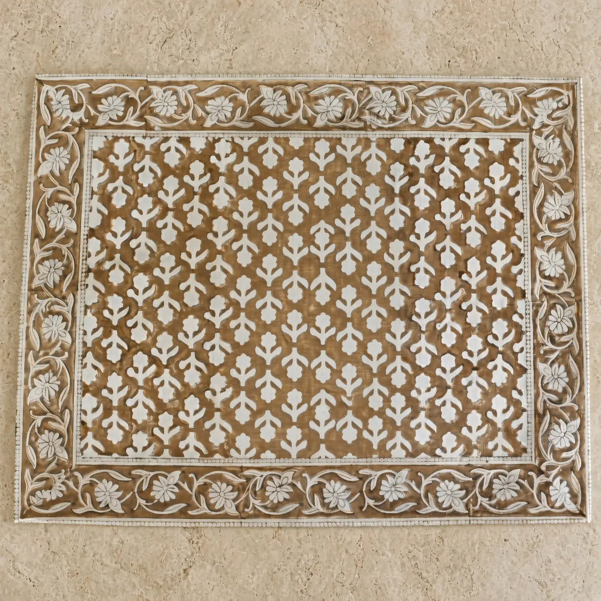 Rectangular beige and white carved wooden block print placemat with intricate floral patterns for table decor