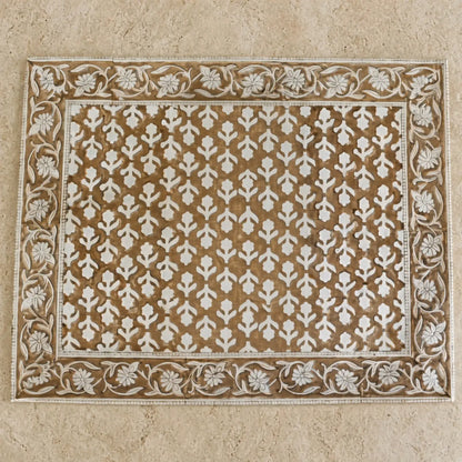 Rectangular beige and white carved wooden block print placemat with intricate floral patterns for table decor