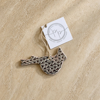 Adorable cardinal ceramic ornament with beautifully imprinted black and beige leaf pattern for holiday décor hanging loop