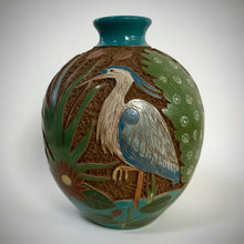 Decorative carved clay heron vase with nature motif and textured clay beneath