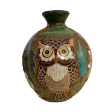 Carved ceramic vase with heron bird designs on a white background.