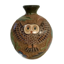 Carved ceramic vase with heron bird designs on a white background.
