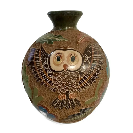 Carved ceramic vase with heron bird designs on a white background.