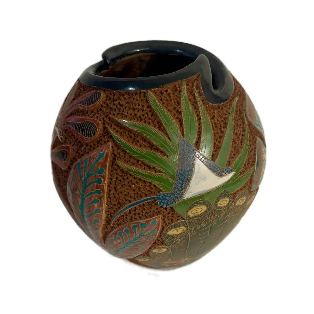 Carved ceramic vase with turtle design on a white background.