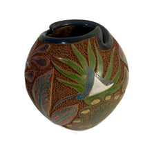 Carved ceramic vase with turtle design on a white background.