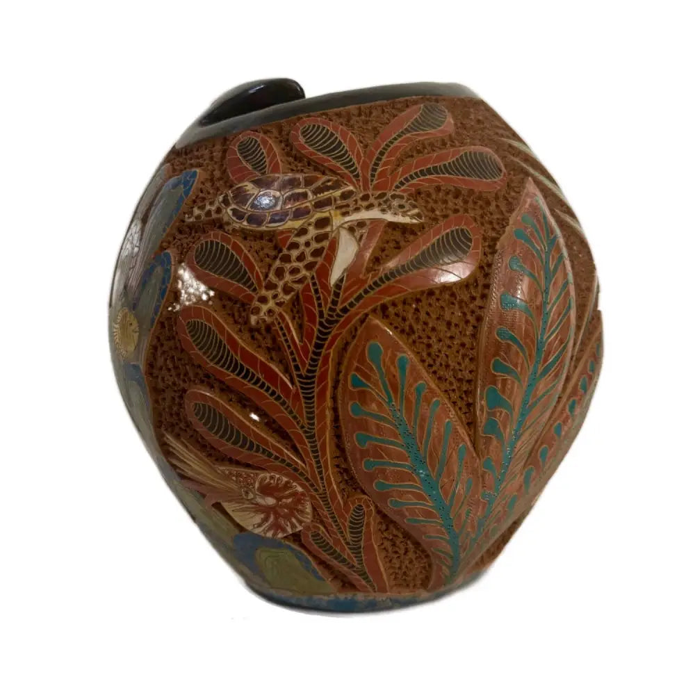 Carved ceramic vase with turtle design on a white background.