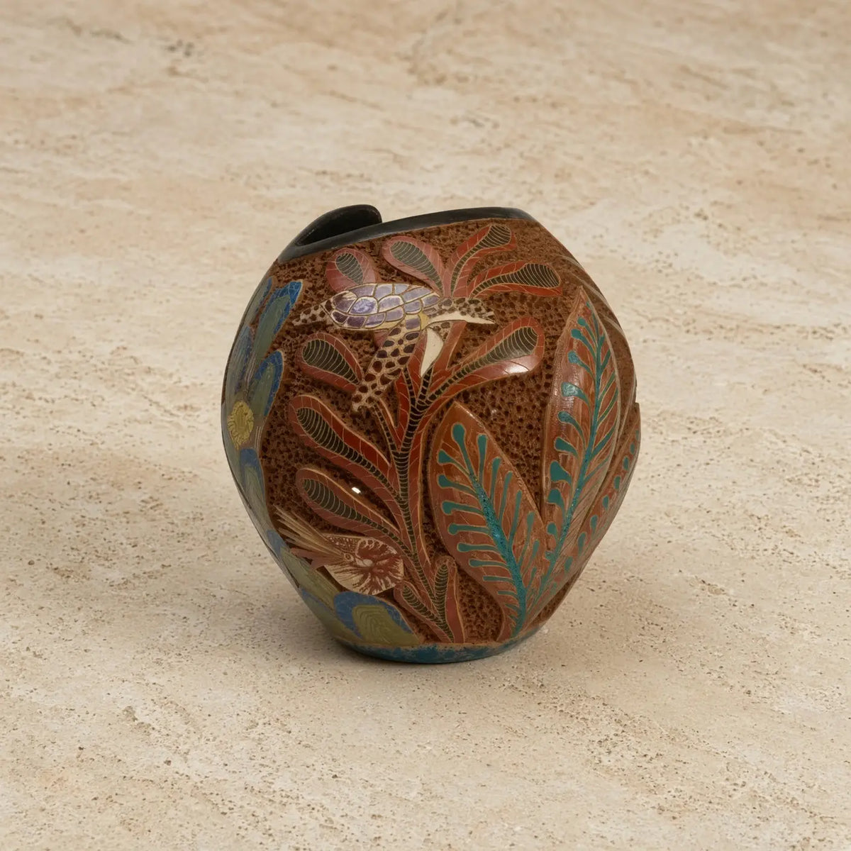 Hand-painted carved clay turtle vase with intricate botanical design in earthy tones to celebrate ocean vibes