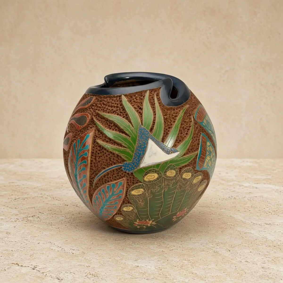 Hand-painted carved clay turtle vase with textured brown body, green and teal botanical motifs, and glossy black rim to celebrate ocean vibes