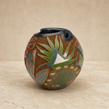 Hand-painted carved clay turtle vase with textured brown body, green and teal botanical motifs, and glossy black rim to celebrate ocean vibes