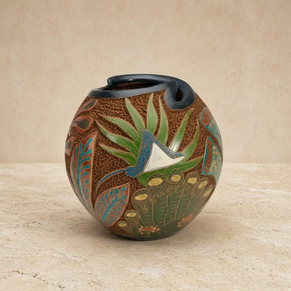 Hand-painted carved clay turtle vase with textured brown body, green and teal botanical motifs, and glossy black rim to celebrate ocean vibes