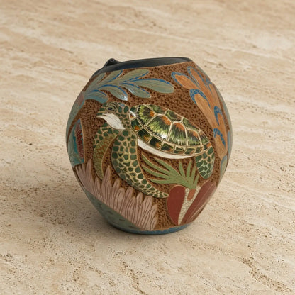 Handcrafted carved clay turtle vase with vibrant green blue orange and brown marine flora to celebrate ocean vibes