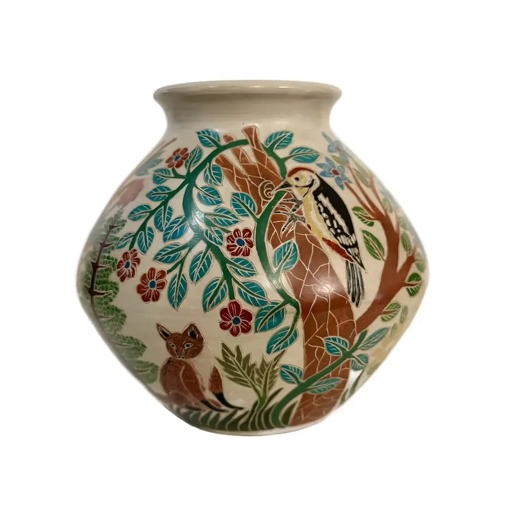 A carved ceramic vase featuring a woodlands habitat against a white background.