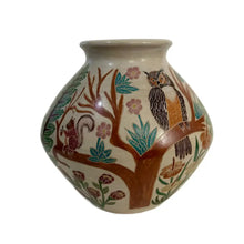 A carved ceramic vase featuring a woodlands habitat against a white background.