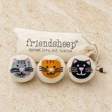 Three handcrafted wool dryer balls in gray orange and black with adorable cat designs for eco laundry use
