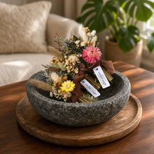 A rustic gray stone bowl filled with colorful dried flowers complements cedar sage bundle for smoke cleansing and grounding energy