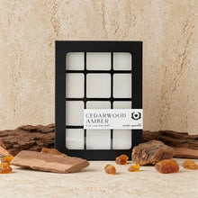 Black-framed box of cedarwood amber soy wax melts with twelve white square cubes for long burn time and cozy scent