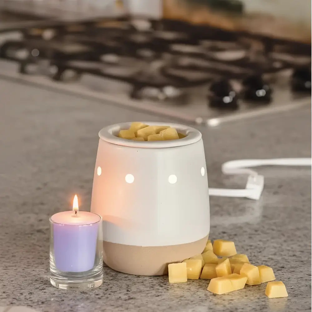 Ceramic electric wax warmer with matte white ceramic bowl and beige base filled with yellow favorite wax melts cubes