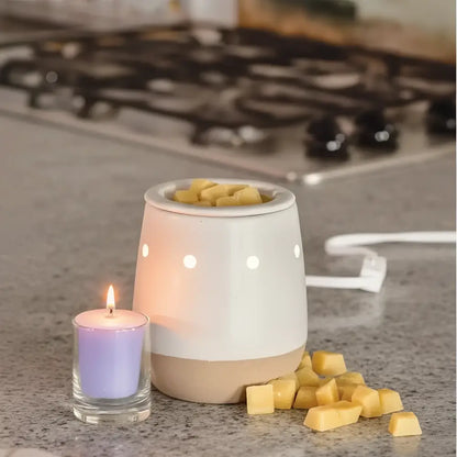 Ceramic electric wax warmer with matte white ceramic bowl and beige base filled with yellow favorite wax melts cubes