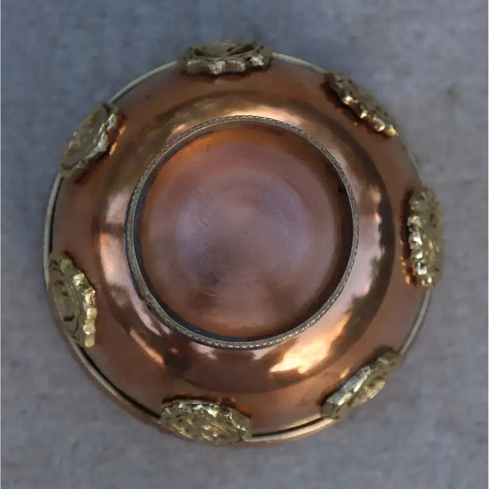 A small copper cone incense offering bowl with ornate gold floral rim perfect for meditation spaces and ritual practices
