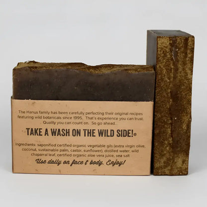 Dark brown chaparral shampoo and body bar soap with wild chaparral leaf and natural ingredients in kraft paper packaging