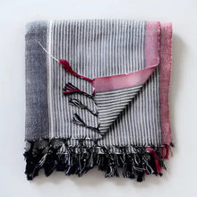 100% Turkish cotton towel that has been hand loomed in a flat weave and hand dyed in charcoal, off white and red colors.