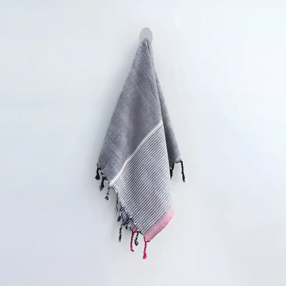 100% Turkish cotton towel that has been hand loomed in a flat weave and hand dyed in charcoal, off white and red colors.